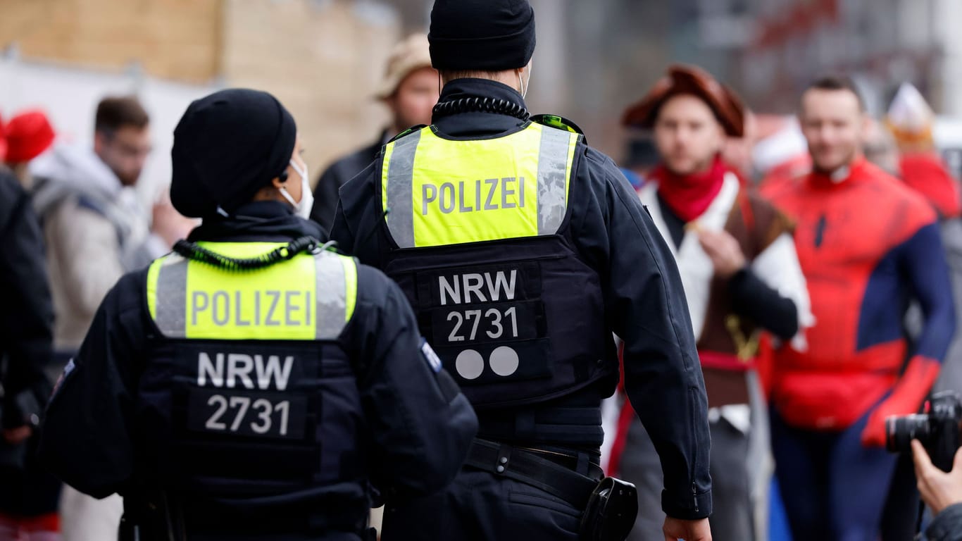 Zwei Polizeibeamte beim Kölner Karneval (Archivbild): Von ihnen soll es in diesem Jahr weniger geben.