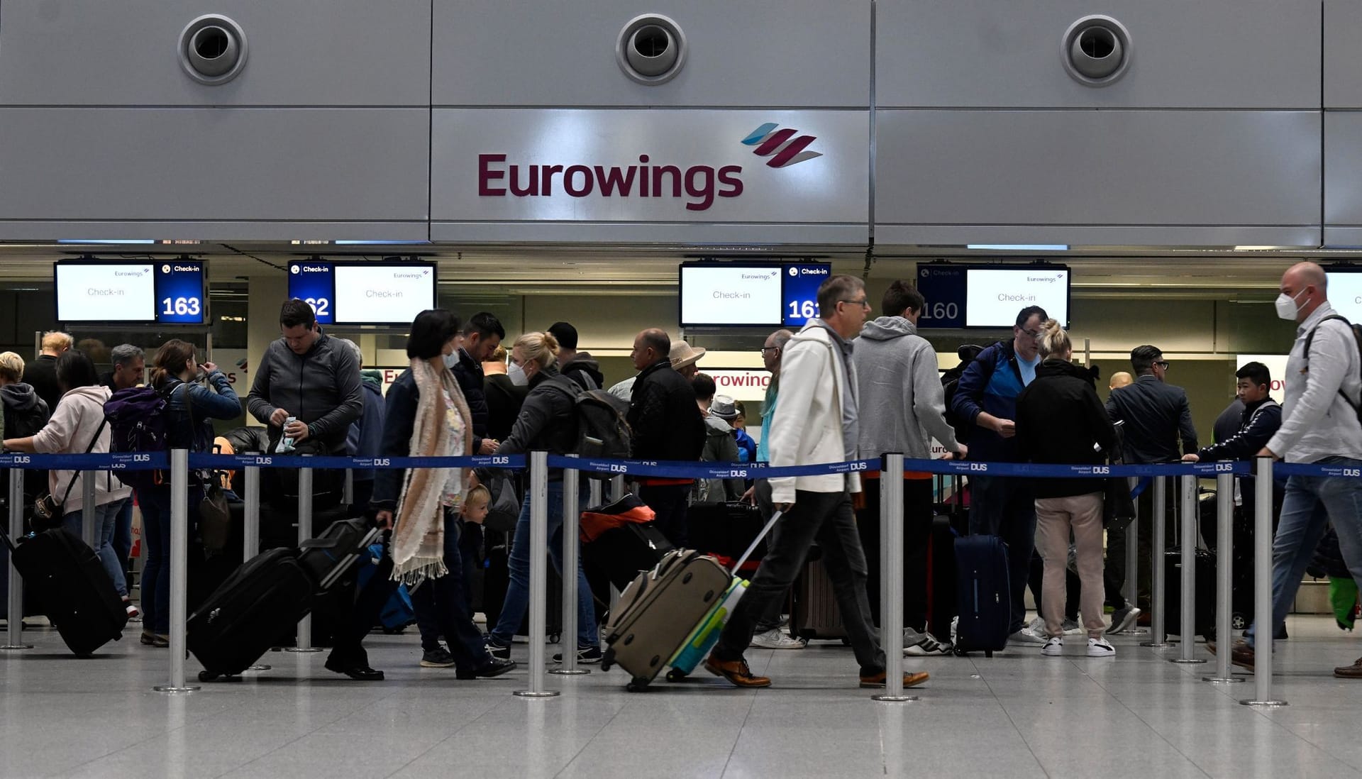 Reisende am Eurowings Check-In-Schalter (Archivbild): Von Montag bis Mittwoch fallen zahlreiche Flüge aus.