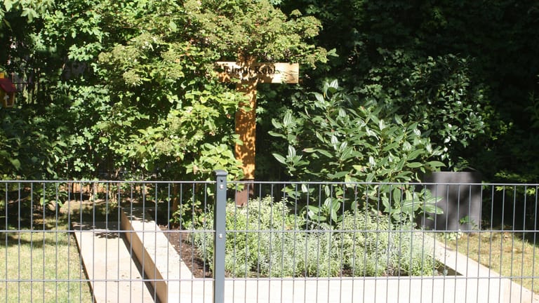 August 2022: Kohls Grab im Speyerer Adenauerpark mit Zaun und Holzkreuz