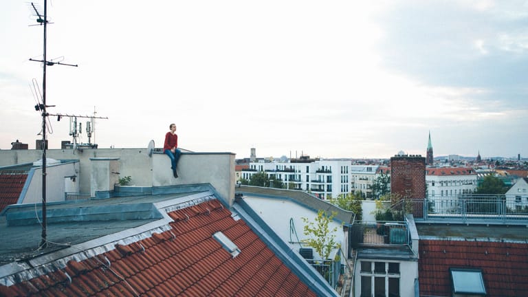 Eine Frau über den Dächern von Berlin (Symbolbild): Berlin ermittelt die neue Grundsteuer wie bisher nach dem Bundesgesetz.