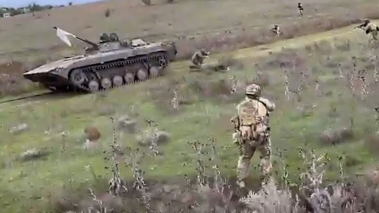 Die russischen Soldaten haben eine weiße Fahne an ihrem Panzer befestigt.