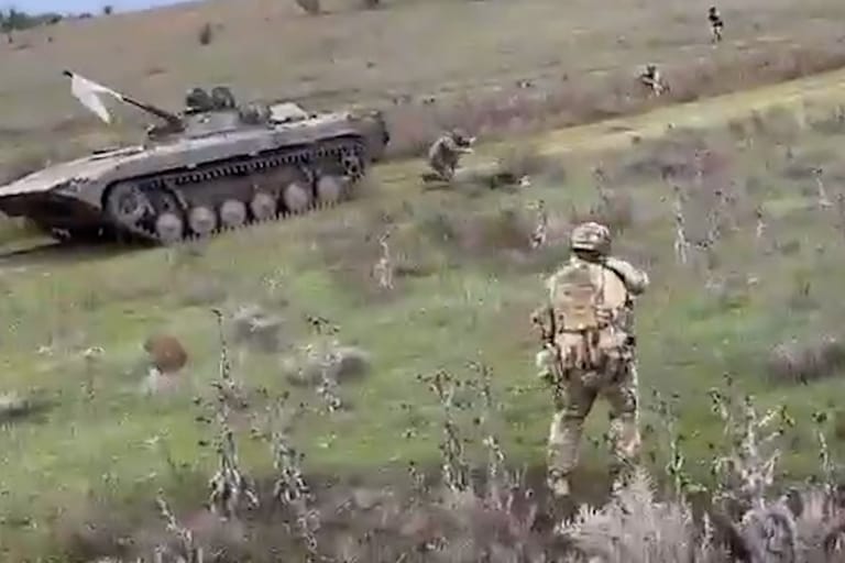 Die russischen Soldaten haben eine weiße Fahne an ihrem Panzer befestigt.
