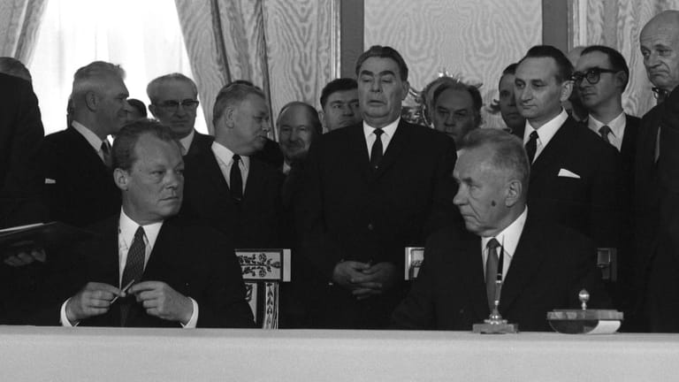 Kanzler Brandt und Ministerpräsident Kossygin unterschreiben den Moskauer Vertrag, im Hintergrund Parteichef Breschnew.