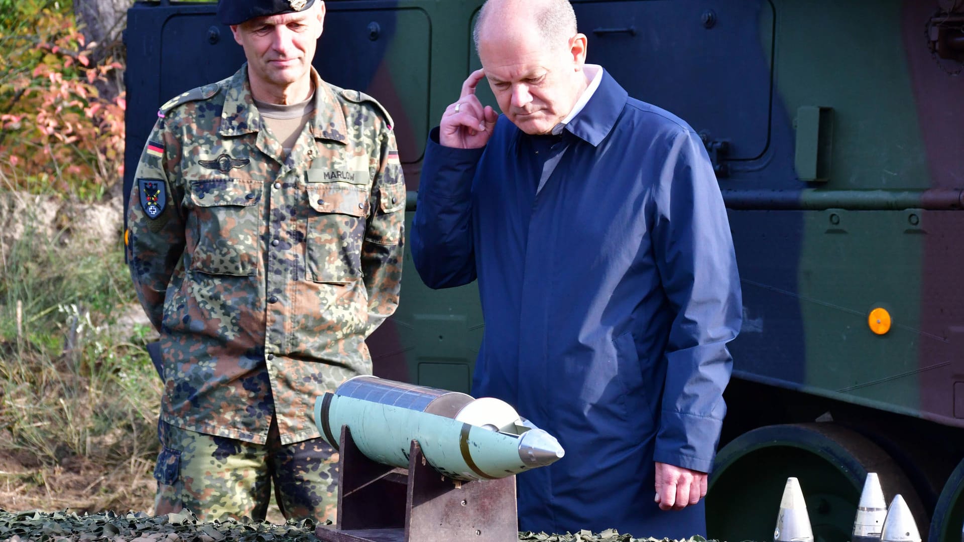 Scholz inspiziert beim Truppenbesuch in der Lüneburger Heide ein Geschoss.