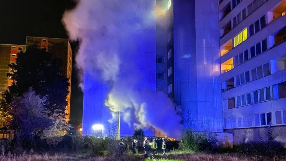 Einsatzkräfte der Feuerwehr vor dem brennenden Haus: Der Fluchtweg für die Bewohner war versperrt.