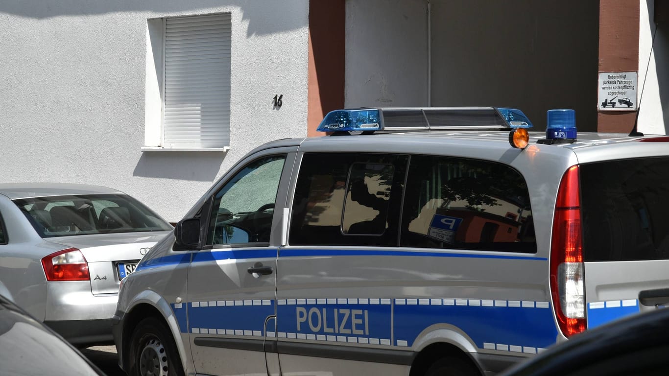 Ein Polizeiwagen vor einem Haus (Archivbild): In Landshut haben Beamte die Wohnung einer 30-jährigen Russin durchsucht.