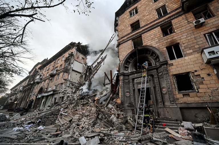Rettungskräfte arbeiten am Einsatzort eines durch Beschuss beschädigten Gebäudes in Saporischschja.