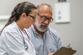 Ärztin im Gespräch mit älterem Patienten