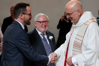 Pfarrer Siegfried Thuringer (r.) beglückwünscht Ex-Mönch Anselm Bilgri (Mitte) und seinen Mann Markus Bilgri.
