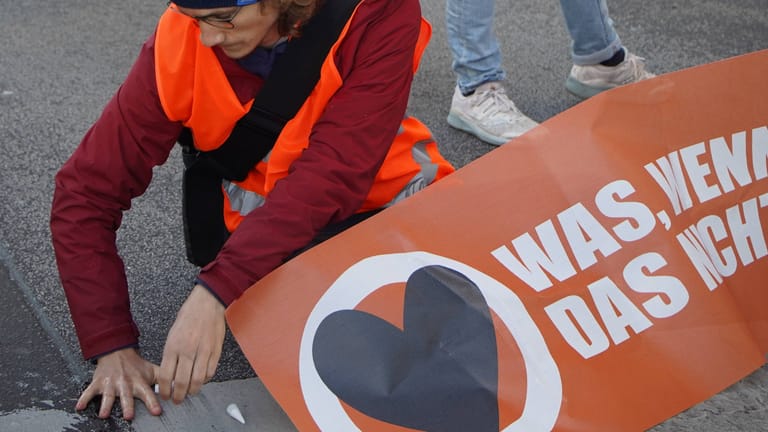 Klimaaktivisten blockieren eine Autobahnabfahrt in Berlin im morgendlichen Berufsverkehr.