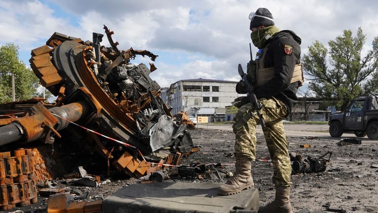 Ukrainischer Soldat neben einem zerstörten russischen Panzer in Kupjansk: Die Stadt hatte die ukrainische Armee aus russischer Kontrolle zurückerobern können.