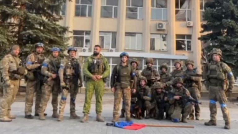 Ukrainische Soldaten stehen vor der Stadtverwaltung von Lyman.