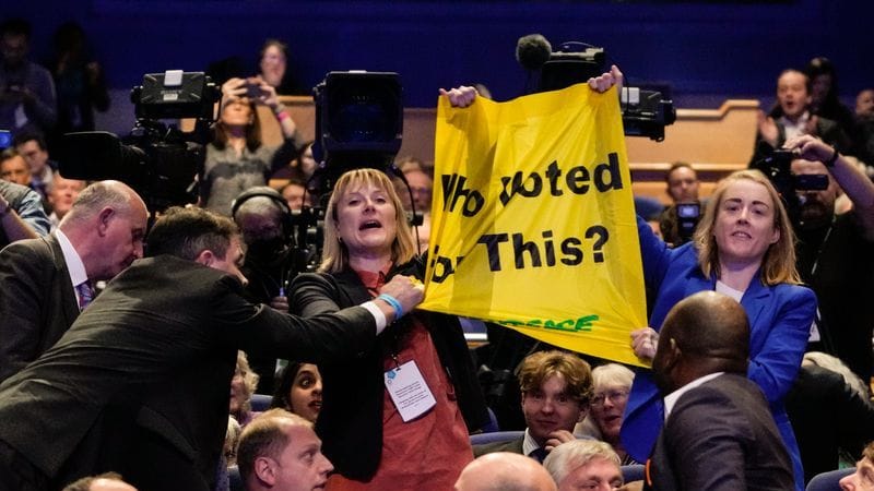 Zwei Demonstrantinnen bei der Rede von Truss: Sie wurden aus dem Saal gebracht.