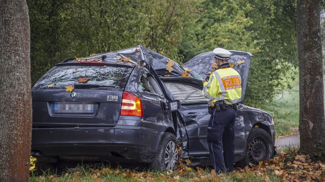 Der zerstörte Skoda wird von einer Polizistin untersucht: In dem Fahrzeug ist am Mittwoch ein 34-Jähriger tödlich verunglückt.
