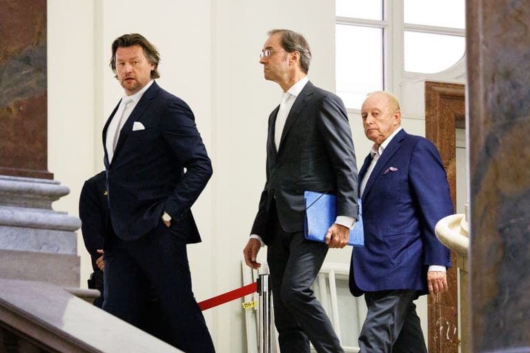 Alfons Schuhbeck (r) nach einer Prozesspause mit seinen Rechtsanwälten Sascha König (l) und Markus Gotzens.