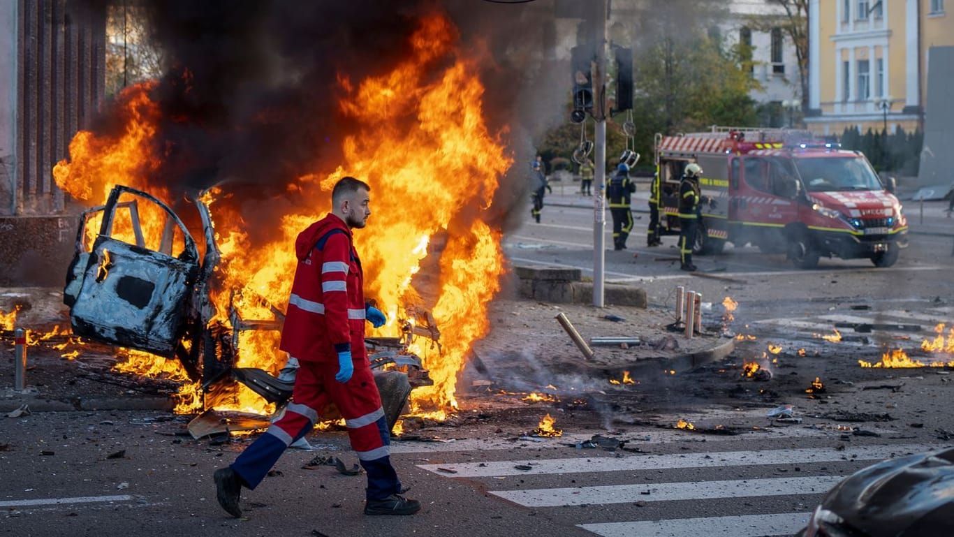 Ein Rettungssanitäter in Kiew: Nach den russischen Angriffen läuft er an einem brennenden Auto vorbei.
