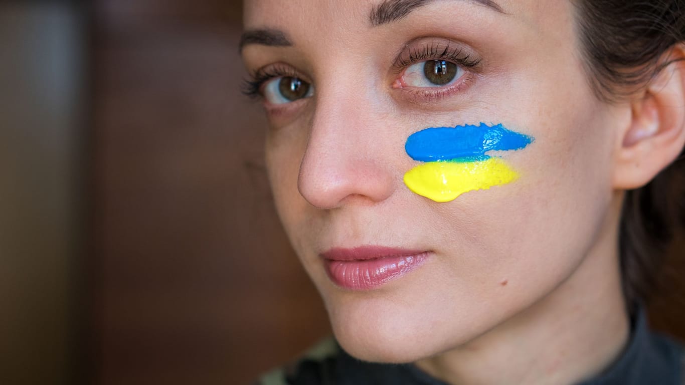 Junge Ukrainerin hat sich die Nationalflagge aufgemalt. Was wissen Sie über die Ukraine?