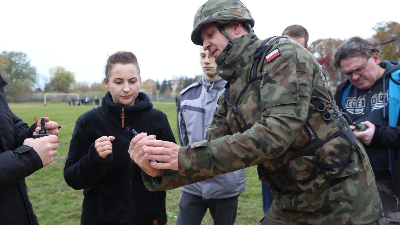 Oberfeldwebel Mariusz Starosz erklärt auf einem Übungsplatz der polnischen Armee Bürgern den richtigen Umgang mit einer Handgranate.