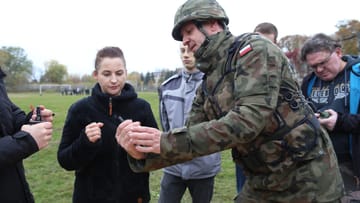 Oberfeldwebel Mariusz Starosz erklärt Bürgern auf einem Übungsgelände der polnischen Armee den richtigen Umgang mit einer Handgranate.