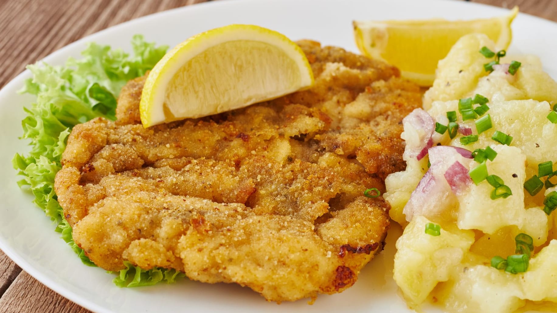 Wiener Schnitzel: Das Original wird mit Kartoffelsalat und einer Zitronenscheibe serviert.