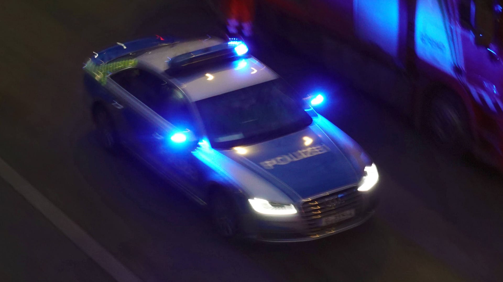 Polizeiauto fährt in der Nacht (Symbolbild): In einem Frühstückscafé in Lichterfelde wurde ein Feuer gelegt.
