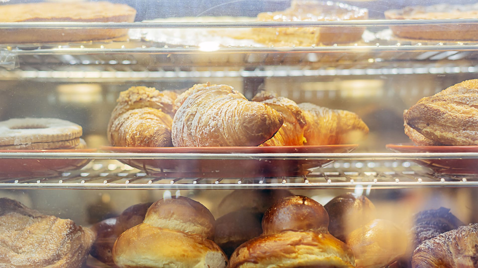 Backartikel liegen in einer Auslage (Symbolbild): Das Magazin "Falstaff" hat Schleswig-Holsteins beliebteste Bäckerei gekürt.