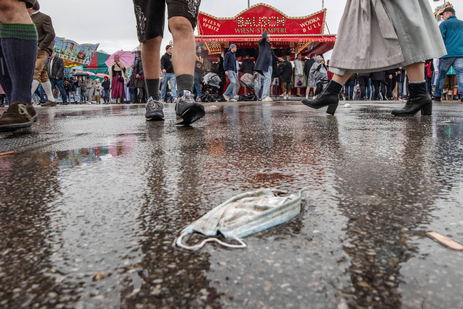 Eine Maske auf dem Boden während des Oktoberfests (Archivbild): Schon während der Wiesn begann in München die Inzidenz rasant zu steigen.