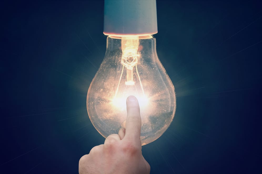 Eine Hand berührt eine leuchtende Glühbirne: Geht Ihnen bei diesen Fragen auch ein Licht auf?