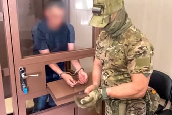 Russischer Beamte mit Verurteiltem (Symbolbild): Bürgerrechtlerinnen und -rechtler informierten zuerst über die Abwerbungsversuche im Gebiet Nischni Nowgorod.
