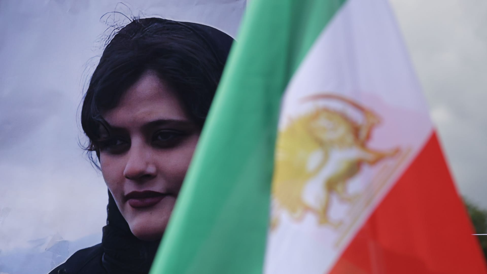 Bild der getöteten Mahsa Jina Amini hinter der iranischen Flagge: Weltweit solidarisieren sich Menschen mit den feministischen Protesten im Iran.