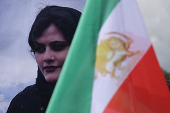 Bild der getöteten Mahsa Jina Amini hinter der iranischen Flagge: Weltweit solidarisieren sich Menschen mit den feministischen Protesten im Iran.
