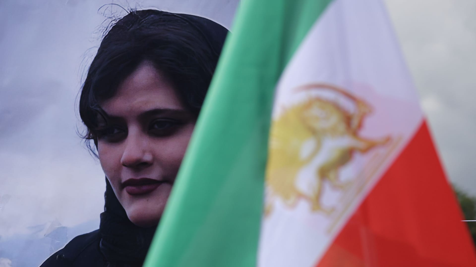 Bild der getöteten Mahsa Jina Amini hinter der iranischen Flagge: Weltweit solidarisieren sich Menschen mit den feministischen Protesten im Iran.