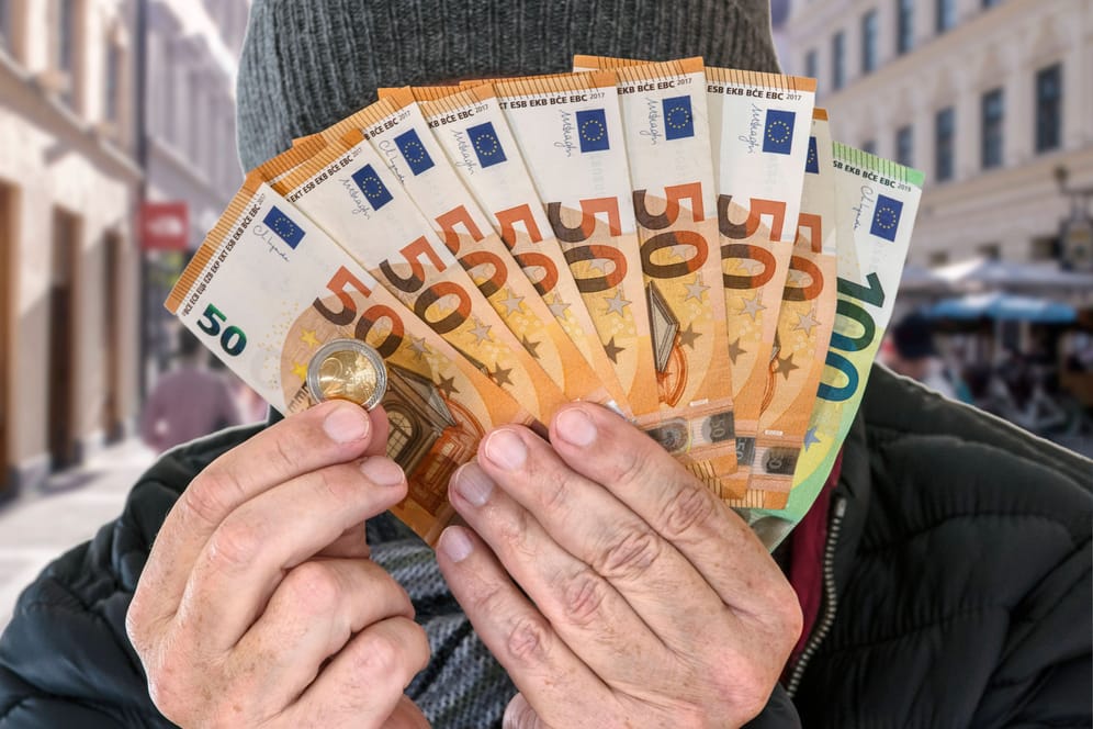 Mann mit Geldscheinen (Symbolbild): Die Lottosieger aus Oberbayern waren bis jetzt hoch verschuldet.
