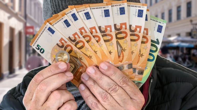 Mann mit Geldscheinen (Symbolbild): Die Lottosieger aus Oberbayern waren bis jetzt hoch verschuldet.