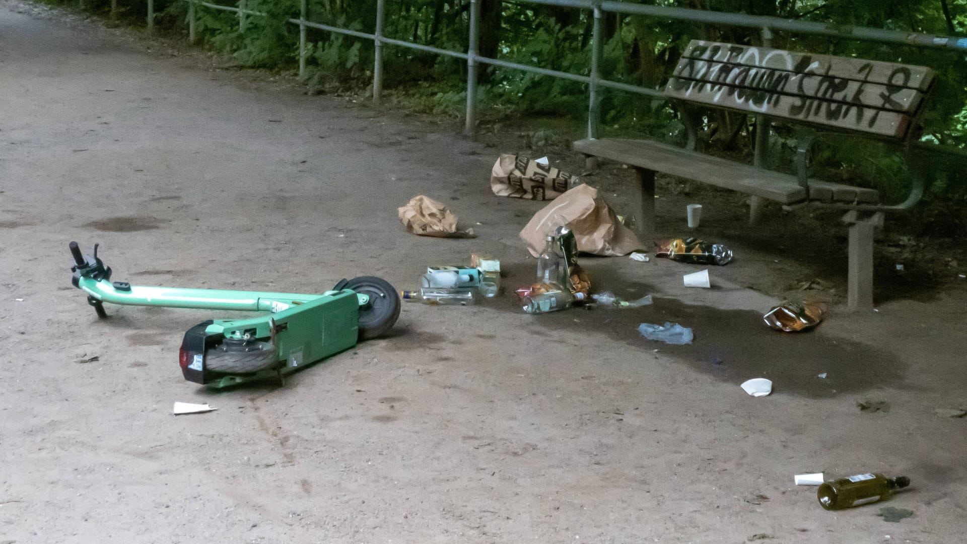 Ein E-Roller und Müll liegen vor einer Parkbank (Symbolbild): In Hamburg soll nun die Stadtreinigung auch um E-Roller kümmern. Ein E-Roller und Müll liegen vor einer Parkbank (Symbolbild): In Hamburg soll nun die Stadtreinigung auch um E-Roller kümmern.