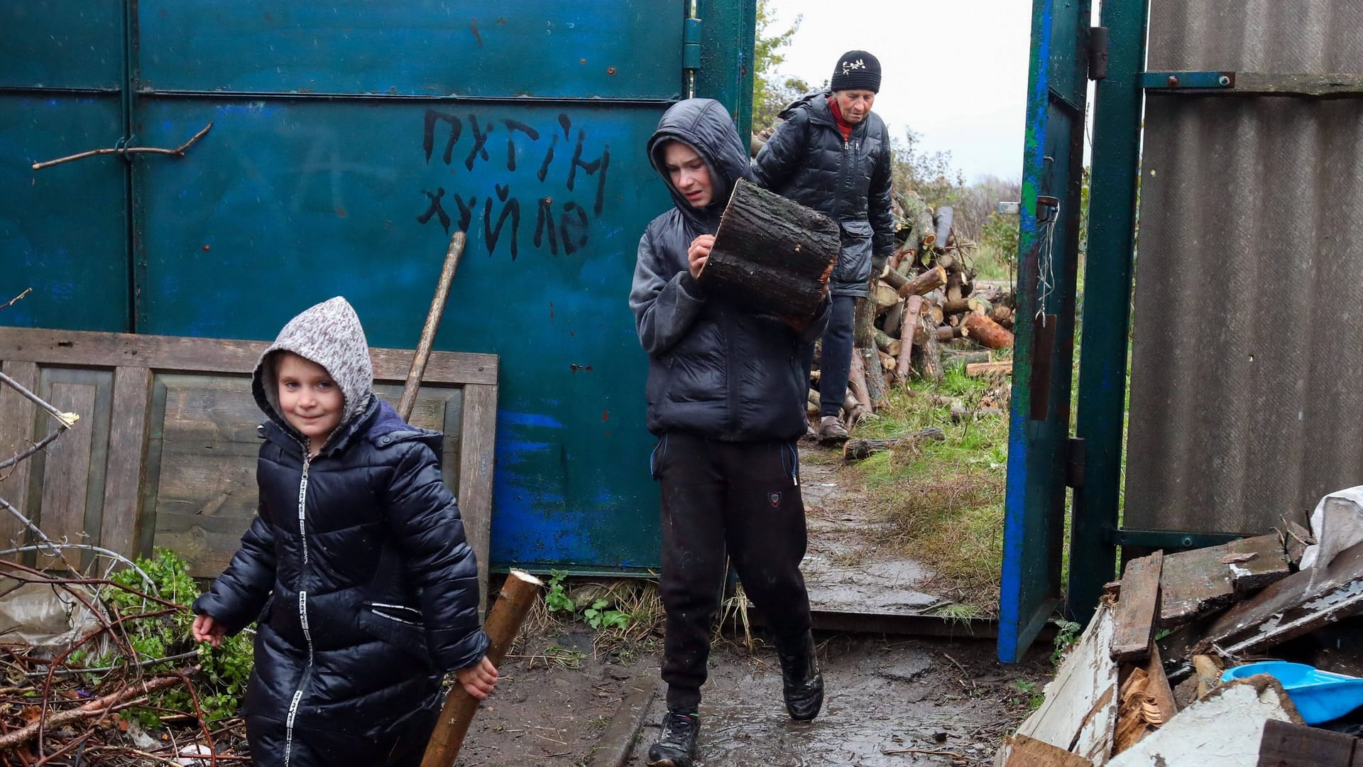 Kinder bringen nahe Charkiw Feuerholz: Die Ukraine rät Geflüchteten, im Ausland zu bleiben.