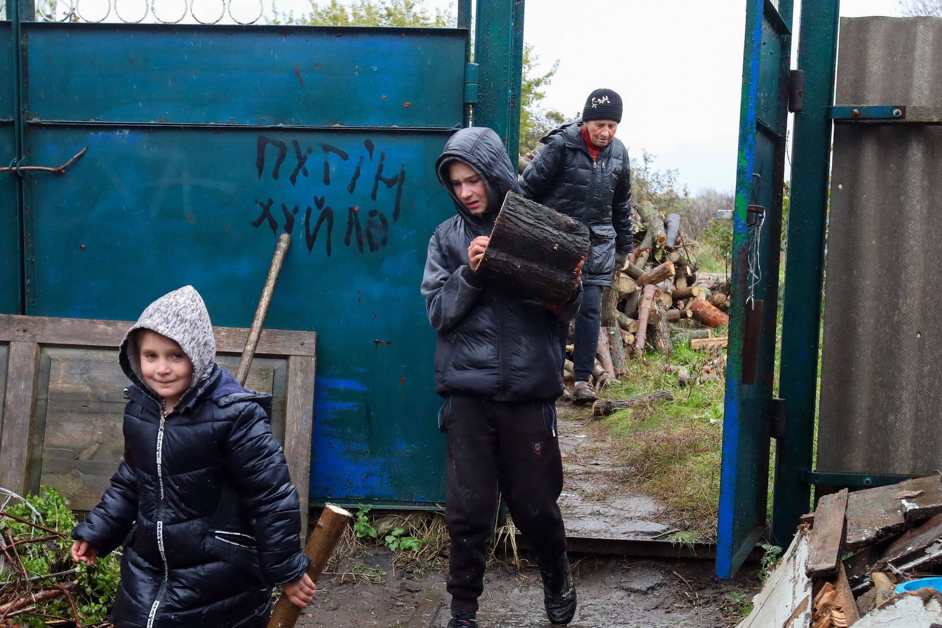 Kinder bringen nahe Charkiw Feuerholz: Die Ukraine rät Geflüchteten, im Ausland zu bleiben.