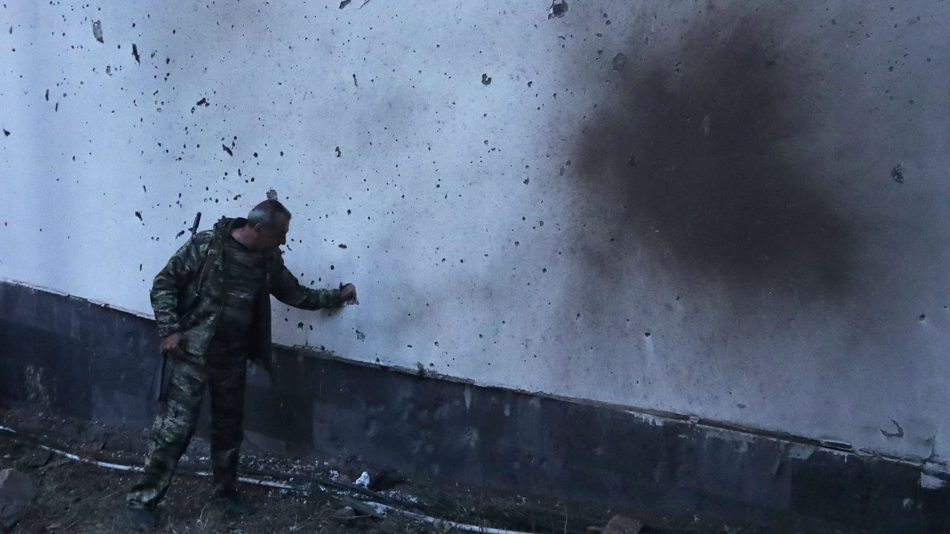 Ein Mann steht neben einer von Beschuss beschädigten Wand in der armenischen Stadt Jermuk: Am 13. September hatte Aserbaidschan das Land angegriffen.