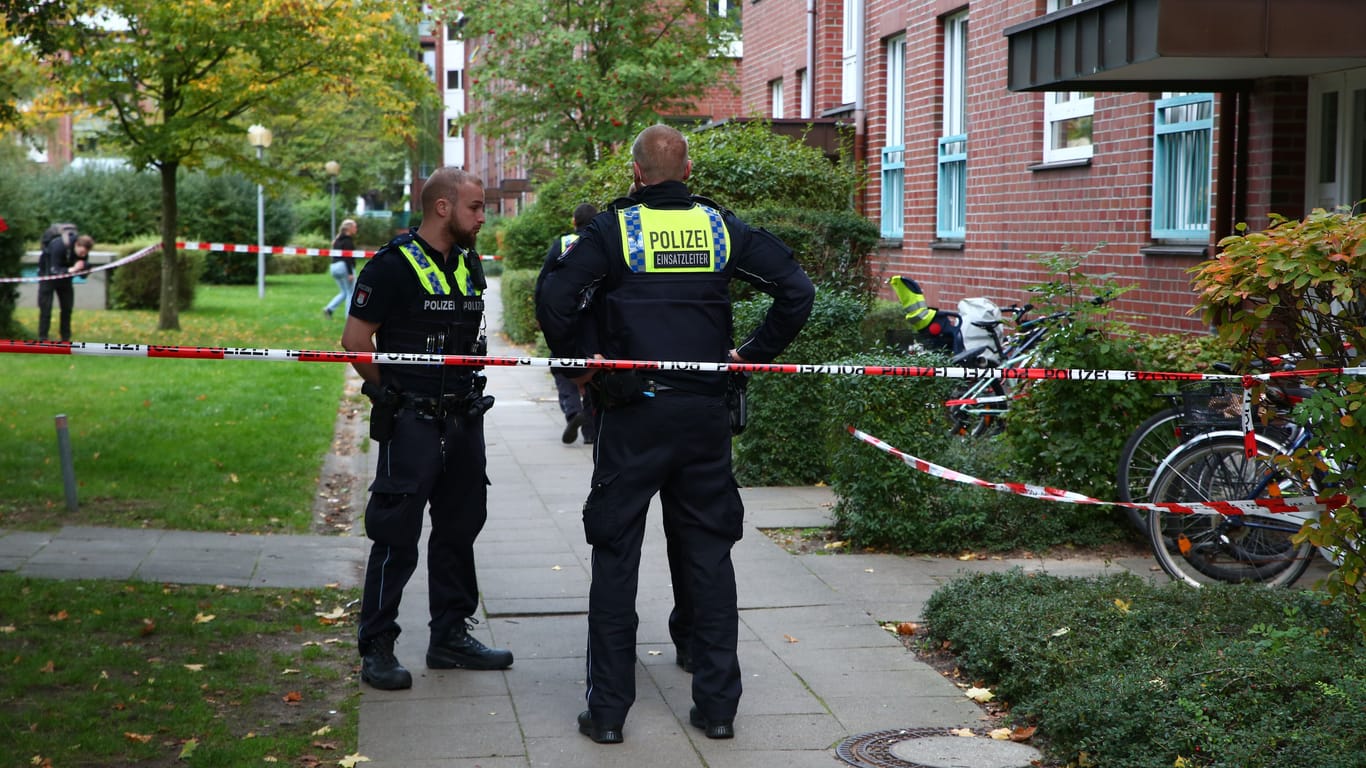 Einsatzkräfte stehen vor dem Mehrfamilienhaus in Farmsen-Berne: Das Opfer kam in ein Krankenhaus.