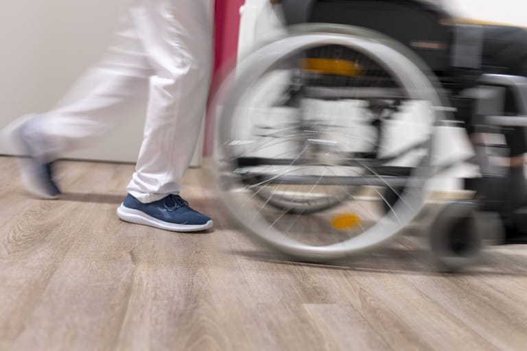 Eine Pflegekraft schiebt einen Rollstuhl (Archivbild): Eine Twitter-Nutzerin wirft ihrem Arbeitgeber öffentlich vor, sie mit einem Mini-Präsent abgespeist zu haben.