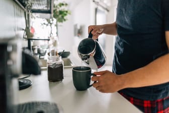 Eine Person bereitet einen Kaffee zu: Für viele gehört das Heißgetränk am Morgen dazu, um wach zu werden und die Konzentration zu steigern.