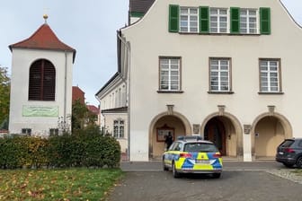 Ein Polizeiauto steht vor einer Kirche: Zwei Sonntagsgottesdienste in Leipzig fanden unter Polizeischutz statt.