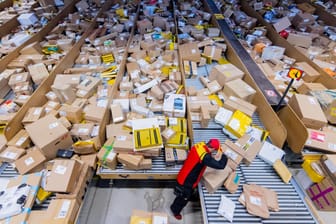 Ein Paketzusteller sortiert Pakete in einer Zustellbasis von DHL: An den Tagen vor Heiligabend erwartet das Unternehmen bis zu 11 Millionen Pakete und Päckchen täglich.