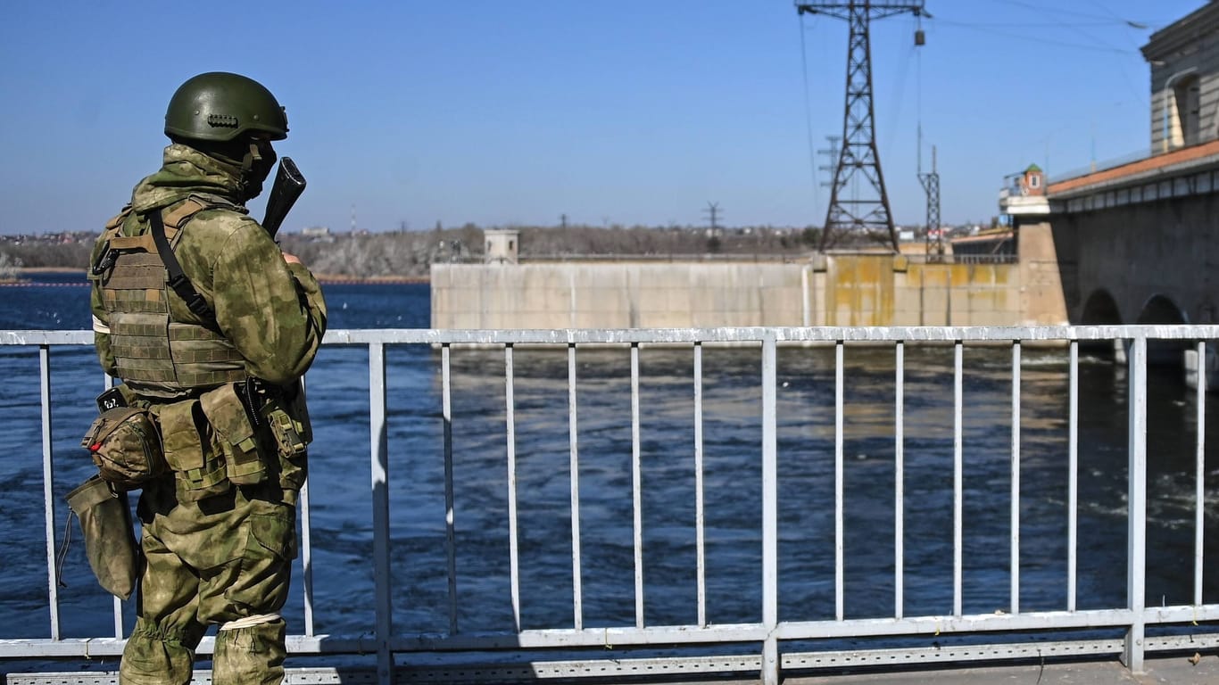 Russischer Soldat blickt auf den Staudamm: Präsident Selenskyj warnt vor einer Sprengung.