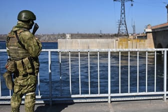 Russischer Soldat blickt auf den Staudamm: Präsident Selenskyj warnt vor einer Sprengung.