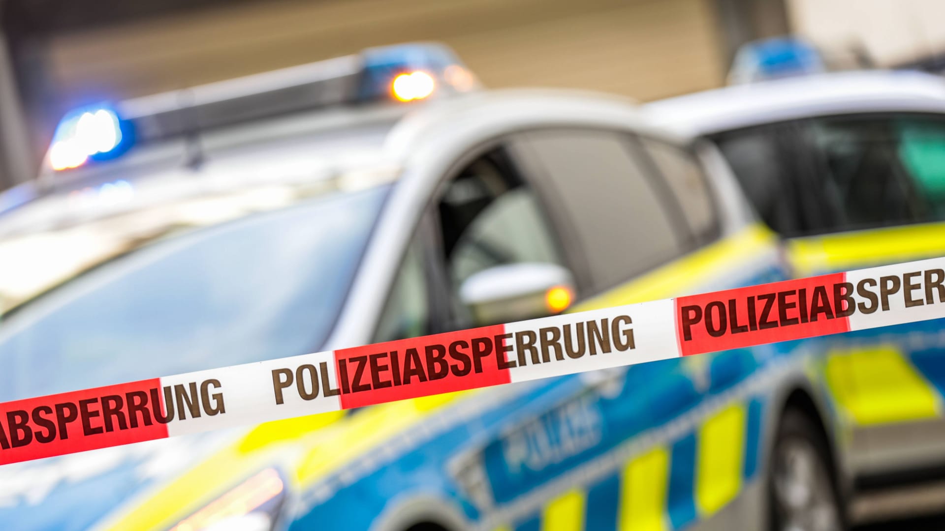 Polizeiabsperrung vor einem Streifenwagen (Symbolbild)