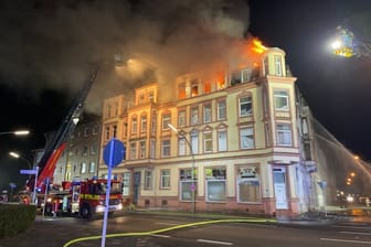 Feuerwehrleute löschen das brennende Wohnhaus.