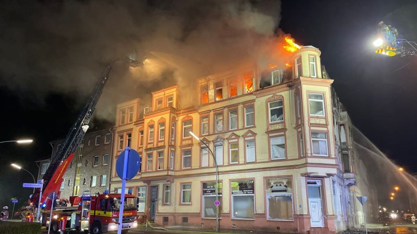 Feuerwehrleute löschen das brennende Wohnhaus.