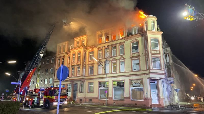 Feuerwehrleute löschen das brennende Wohnhaus.