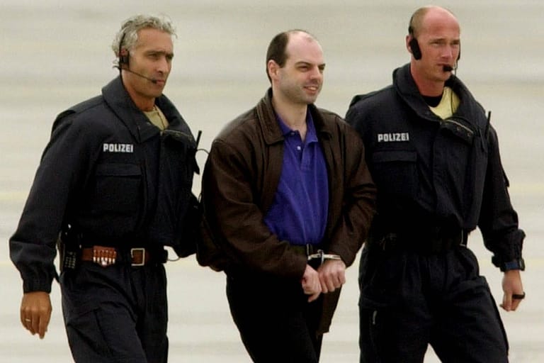 Angeklagter Thomas Drach wird von Polizisten auf dem Flughafen Hamburg abgeführt. (Archivbild)
